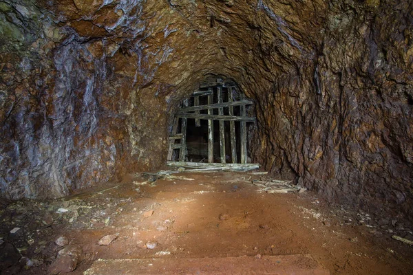 Underground gold mine shaft tunnel drift with wooden timbering