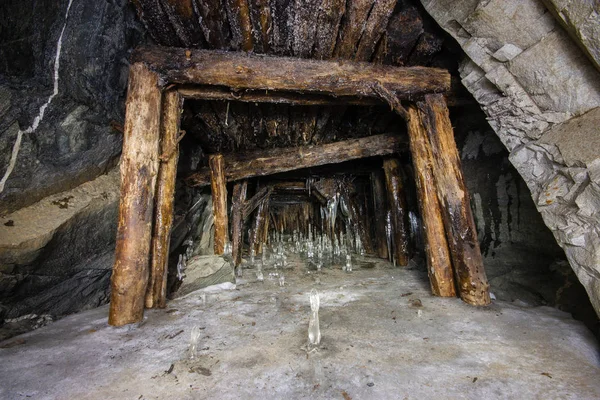 Underground gold mine shaft tunnel drift with timbering and ice