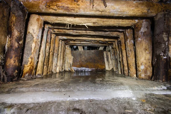 Underground gold mine shaft tunnel drift with timbering and ice