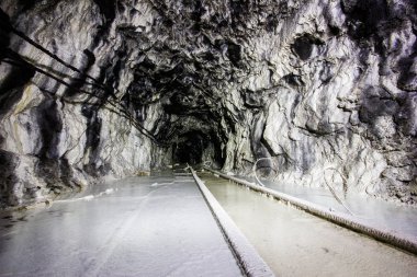Yeraltı altın madeni tüneli beyaz raylarla sürükleniyor.