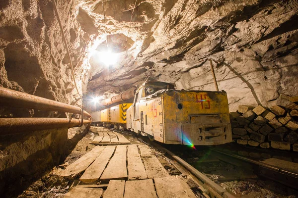 Electric locomotive in underground gold mine shaft tunnel