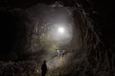 Yeraltı kuvars madenindeki büyük mağarada madenci.