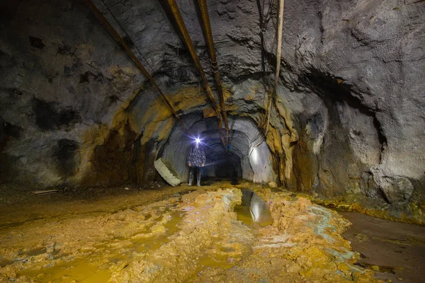 Underground gold mine shaft tunnel drift with yellow water