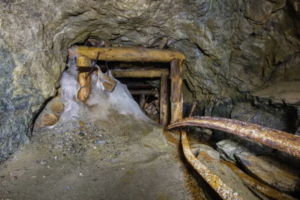 Old gold mine underground tunnel with collapsed wooden timbering
