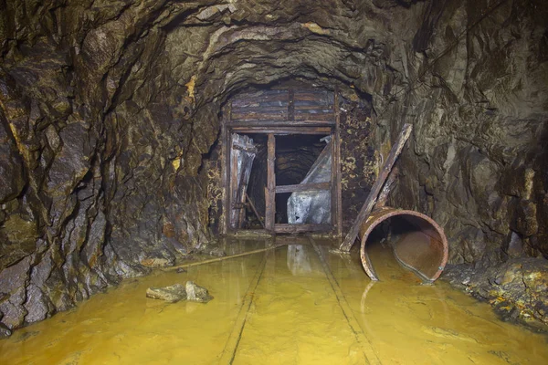 Old gold mine underground tunnel with yellow dirt