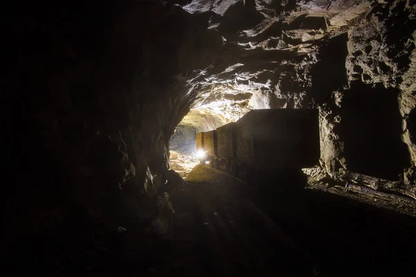 Underground gold mine shaft tunnel drift with rails and wagons mining carts