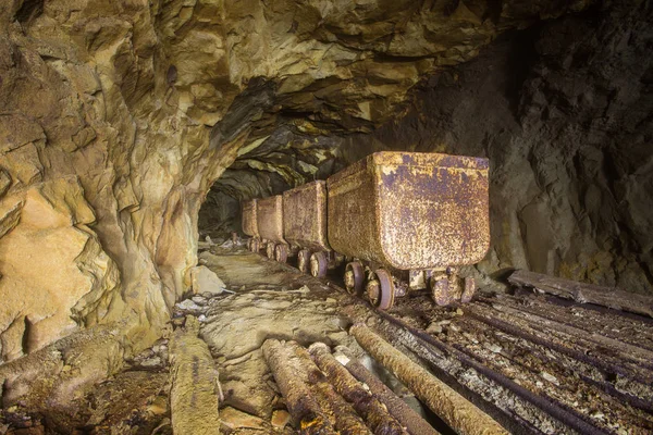 Underground gold mine shaft tunnel drift with rails and wagons mining carts