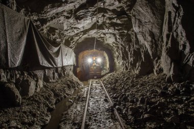 Elektrik lokomotifi yeraltı altın madeni tünelinde.
