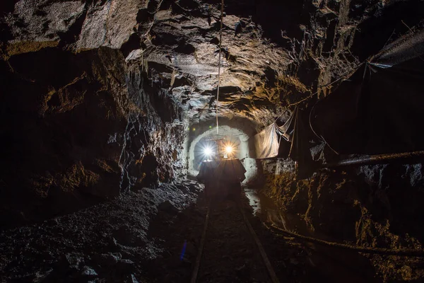 Electric locomotive in underground gold mine shaft tunnel