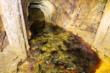 Terk edilmiş bakır madeni, yer altı tüneli ve sarı toprak.