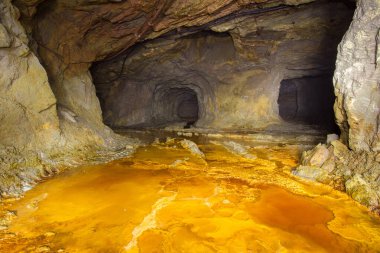 Terk edilmiş bakır madeni, yer altı tüneli ve sarı toprak.