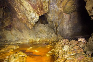 Terk edilmiş bakır madeni, yer altı tüneli ve sarı toprak.