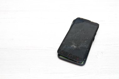 Kırık akıllı telefon beyaz bir kara zeminde