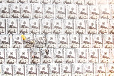 Açılan 100 dolarlık banknotların arkasındaki minyatür alışveriş arabası, nakliye konsepti.