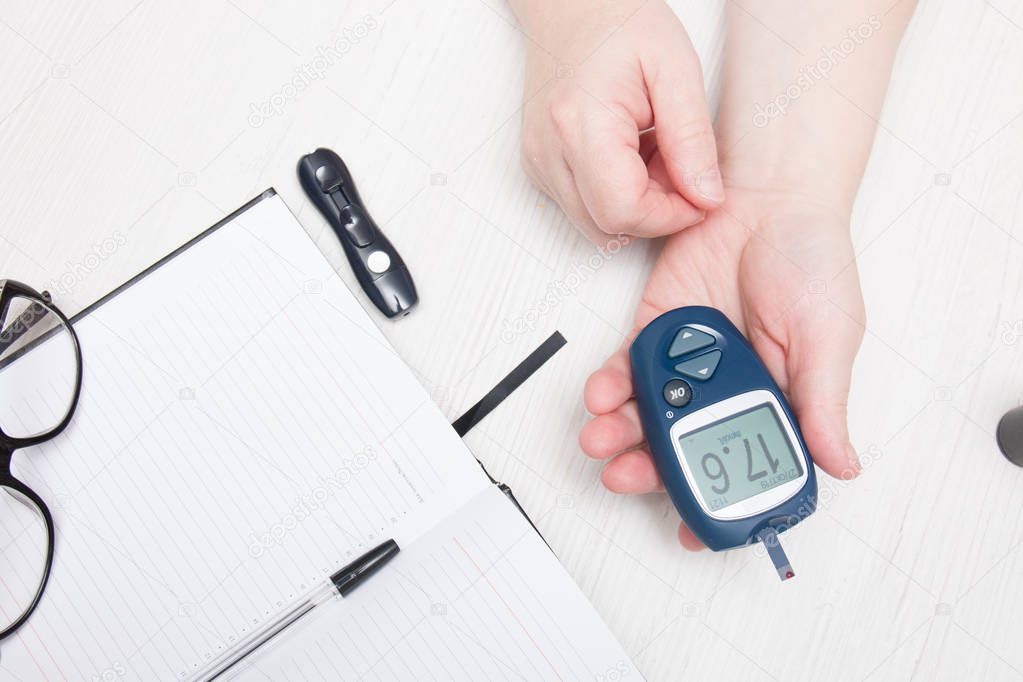 woman measures blood sugar glucose meter, diabetes concept, blood from a finger, glucose test, high blood glucose