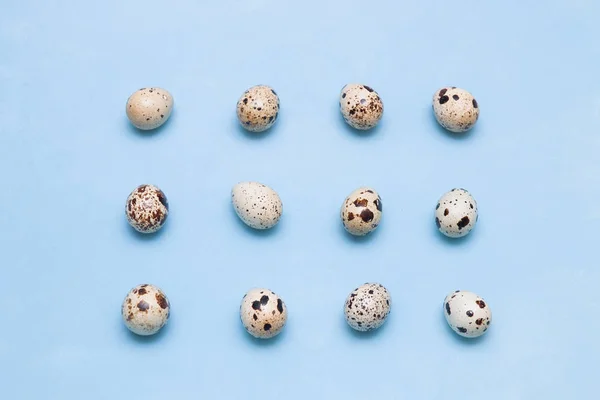 Pattern of quail eggs on a blue background. proper nutrition concept. easter background, minimalism,top view