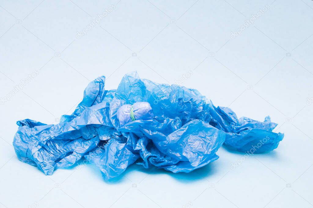 a lot of blue shoe covers on a blue background, copy space, a small bundle of shoe covers tied with an elastic ban