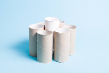 Tuvalet kağıdı kolları sifonu çeker, bir kolu beyaz ve diğerlerinden daha yüksektir, mavi arka plan, kopyalama alanı, liderlik kavramı