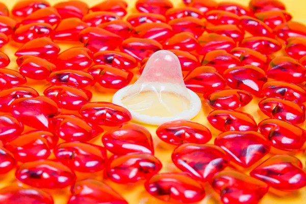 Kondom Mnoho Malých Skleněných Červených Srdcí Žluté Pozadí Chráněné Sexuální — Stock fotografie