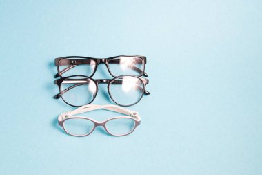 mavi zemin üzerinde görme düzeltmesi için çeşitli gözlük; kopyalama alanı, çocuk gözlüğü ve yetişkinler için küçük nehirler