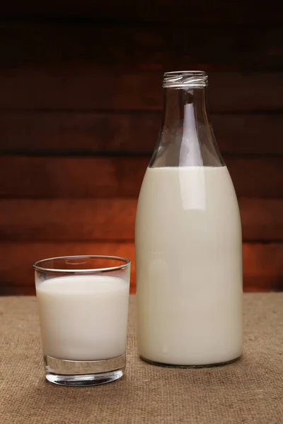Milk in a drink glass and in a glass bottle — Stock Photo, Image