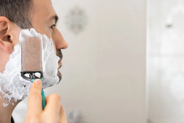 Adam banyoda jilet mirron köpük tıraş — Stok fotoğraf