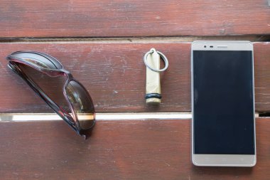 Güneş gözlüğü cep telefonu otel anahtar zinciri ahşap masa Bozcaada Çanakkale 2017 Türkiye'ye yansımaları