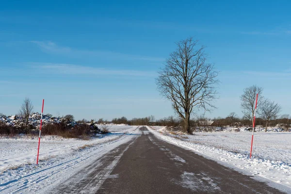 Снежная сельская дорога со снежными кольями — стоковое фото