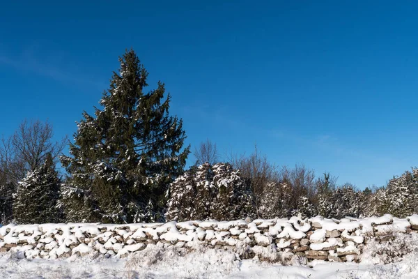 Pared de piedra cubierta de nieve y un cielo azul —  Fotos de Stock