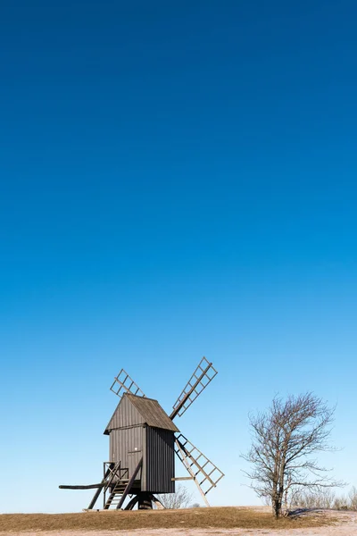 Velho moinho de vento de madeira em uma colina — Fotografia de Stock