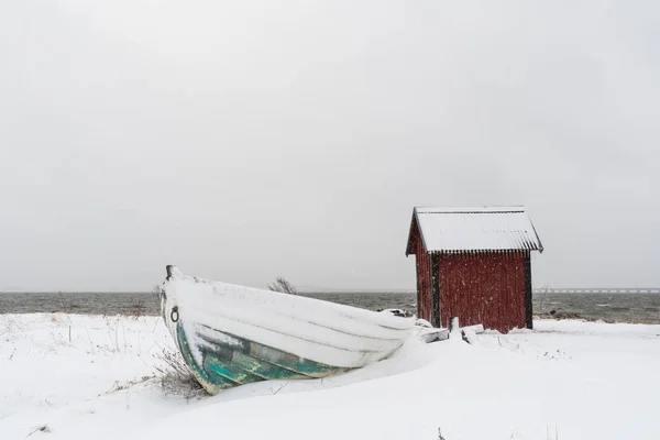 Barco a remos nevado e uma casa de barcos — Fotografia de Stock