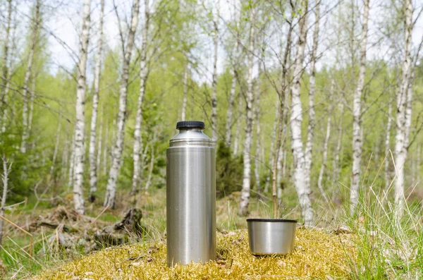 Thermos with cup in a bright forest — Stock Photo, Image
