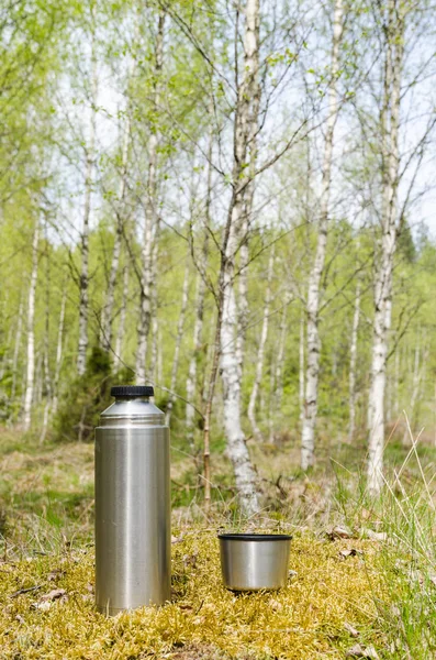 Thermos with beverages in a bright forest — Stock Photo, Image