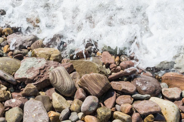 Nasse Steine mit schäumendem Wasser — Stockfoto