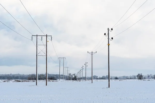 Linie energetyczne w śnieżny krajobraz — Zdjęcie stockowe