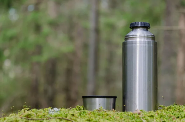 Thermos in a mossy  forest — Stock Photo, Image