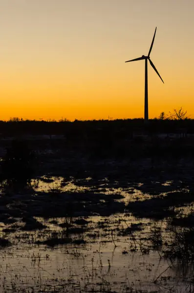 Windmill silhouette in a plain landscape with water reflections — Stock Photo, Image