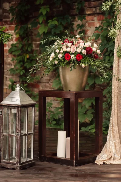 Lâmpada de vela com um buquê de flores vermelhas e brancas . — Fotografia de Stock