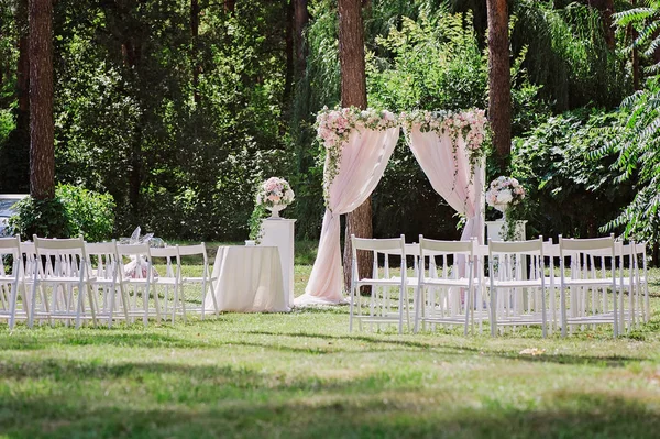Łuk na ceremonię ślubną, ozdobiony tkaniną i kwiatami — Zdjęcie stockowe