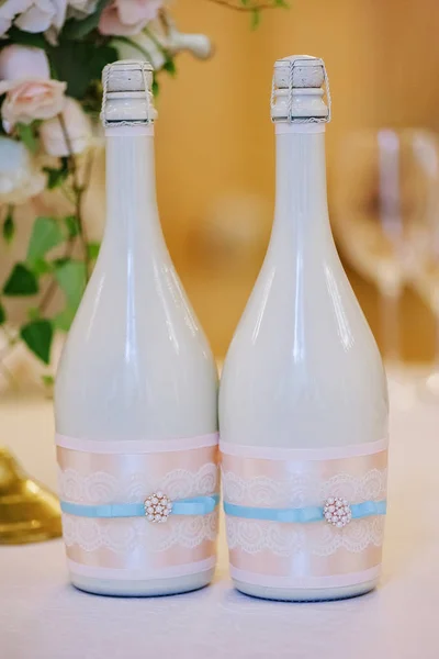 Zwei geschmückte Flaschen Champagner auf der Hochzeitsfeier — Stockfoto