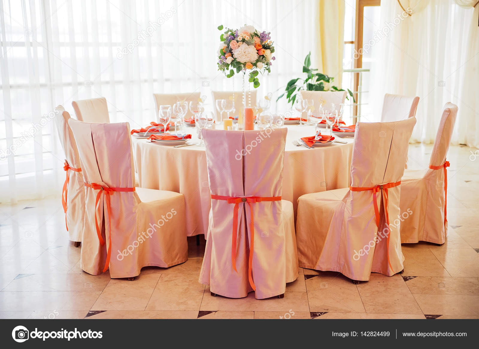 Wedding Guest Table Decorated With Bouquet And Chairs With Bows