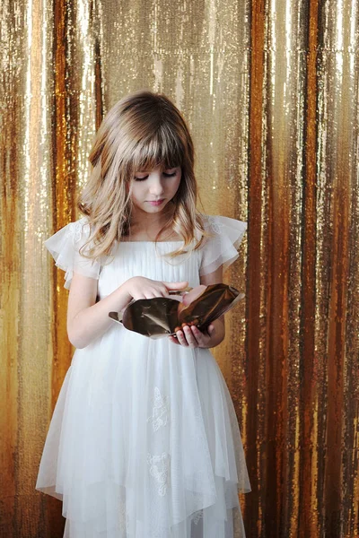 Young girl with golden rose on golden background