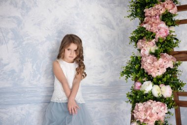 Bir stüdyoda mavi bir elbise, sevimli küçük bir kız fotoğrafı