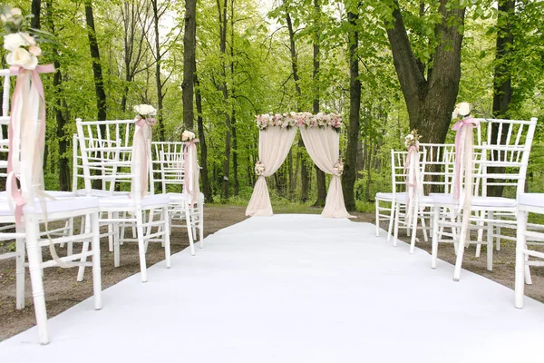 Arco de casamento adorável com cadeiras alinhadas — Fotografia de Stock