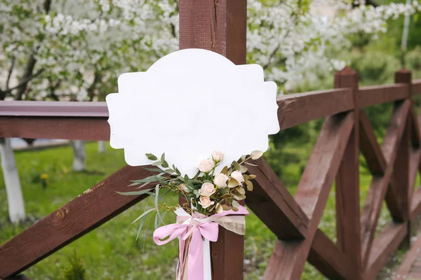 Zubehör, weißes Namensschild mit schönem Boutonniere und Schleife — Stockfoto