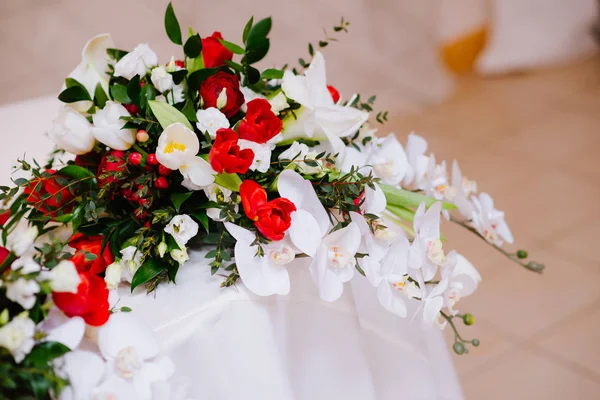 Gorgeous bouquet of orchid and roses on newlyweds table