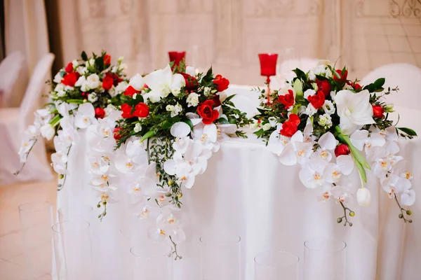 Nygifta tabell dekorerad med vackra bukett av orkidé och rosor — Stockfoto