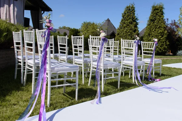 Decoração floral das cadeiras para a cerimônia de casamento exterior — Fotografia de Stock