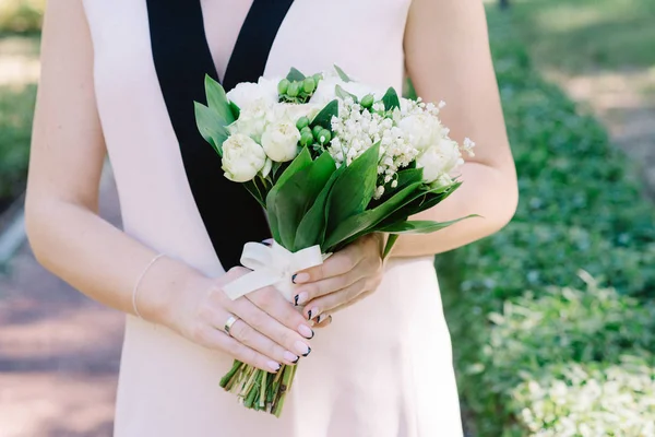 Buquê de casamento elegante lírio do vale nas mãos da noiva — Fotografia de Stock