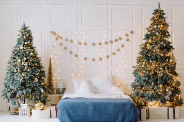 Yumuşak bir yatağı olan şık bir Noel iç tasarımı. Huzur evi. Oturma odasının altında hediyelerle Noel ağacı